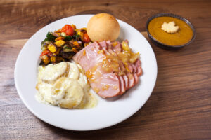 Applewood smoked ham with our pineapple bourbon sauce, potatoes au gratin, roasted seasonal vegetables, dinner rolls, and sweet potato pumpkin pie