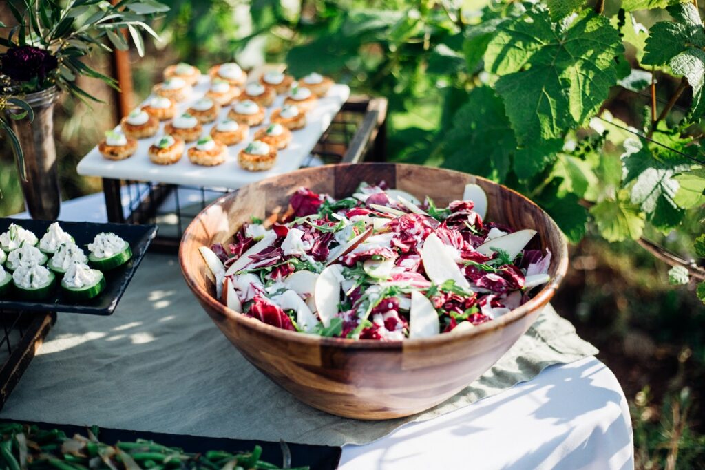 Wedding buffet with crab cakes and radicchio apple salad set up among the vines, catered by Elephants Catering & Events in the Portland area